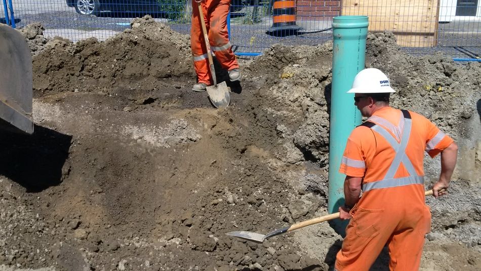 Gas workers working on a gas pipe in a residential area.